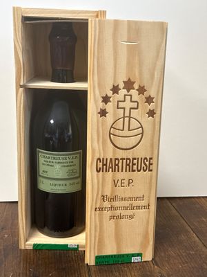 La bouteille de vin se trouve dans la caisse en bois posée sur la table.