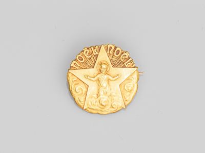 un gros plan d'une médaille d'or sur laquelle figure un ange