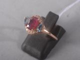 an image of a close up of a ring with a red and blue stone