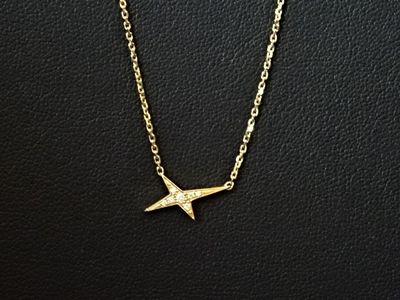 un collier en or orné d'un petit oiseau