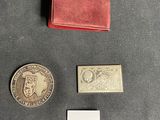 two coins and a small red wallet sitting on a table