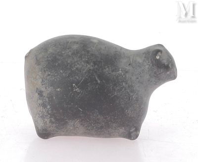 une petite figurine d'animal posée sur une surface blanche