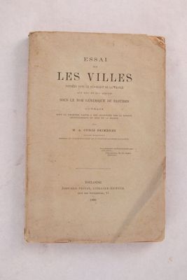 un vieux livre posé sur une table à côté d'un mur blanc