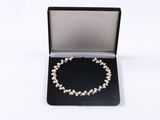 a close up of a bracelet in a box on a white surface