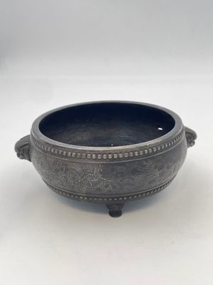a close up of a metal bowl on a white surface