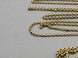 a close up view of a gold chain with a heart on it