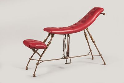une photo d'un fauteuil en cuir rouge avec un repose-pieds