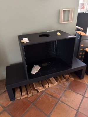a black table with a firewood holder on top of it