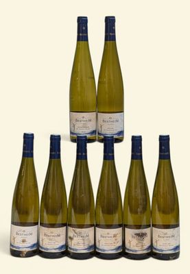 six bouteilles de vin blanc sont disposées en pyramide sur une surface blanche