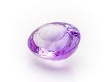 a close up of a purple gemstone on a white surface