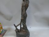 a statue of a woman holding a hammer next to a book