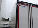 a truck that is driving down the road in front of a building