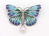 broche en forme de papillon violet et bleu ornée d'une perle sur fond blanc