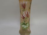 un vase avec des fleurs peintes dessus, posé sur une table