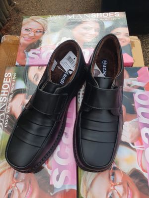 une paire de chaussures en cuir noir pour homme posée sur un magazine