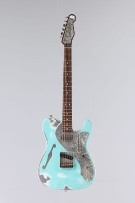 une guitare électrique suspendue à une corde sur un fond gris
