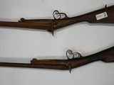 two old guns are displayed on a wall in a room