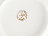 a white plate with a gold emblem on it