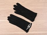 a pair of black gloves sitting on top of a wooden floor