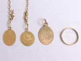 three gold coin necklaces and a gold ring on a white surface