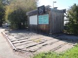 a small wooden building with a sign on the side of it