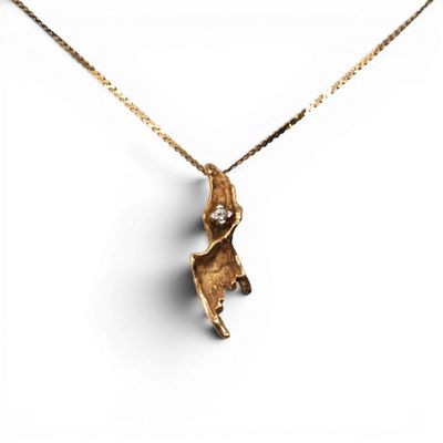 gros plan d'un collier en or sur fond blanc