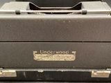 an old typewriter sitting on top of a black suitcase