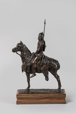 statue représentant un homme à cheval, muni d'une lance, posée sur un socle en bois