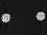 une paire de boucles d'oreilles en diamant posées sur un fond noir