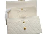 a close up of a white purse on a white background