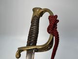 an old sword with a red rope hanging from it ' s end