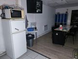 a small kitchen with a refrigerator, microwave and table in it