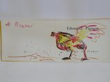 le dessin d'un coq sur une carte postale posée sur une table