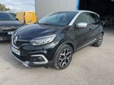 a black renault kad suv parked in front of a garage