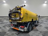 a large yellow truck that is parked on a checkered floor