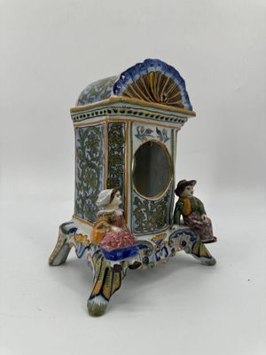 une figurine représentant un homme et une femme assis sur un banc
