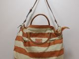 an orange and white striped purse hanging on a wall