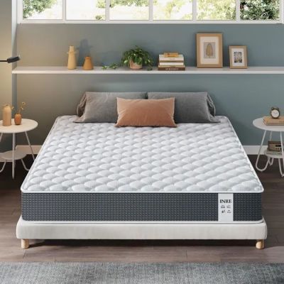 une photo d'un matelas dans une chambre à coucher, avec une fenêtre en arrière-plan
