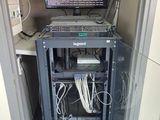une image représentant une armoire de serveurs sur laquelle est posé un ordinateur