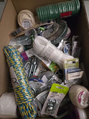 une boîte en carton remplie de pelotes de laine de toutes sortes et d'autres objets