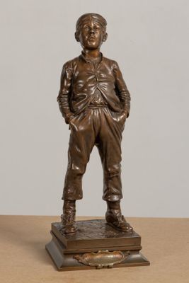 bronze statue of a man standing on a base with his hands in his pockets