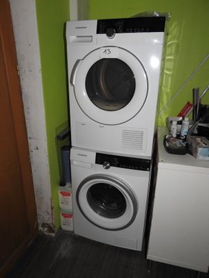 une rangée de lave-linge et de sèche-linge dans une petite pièce