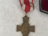 a medal and a red and white ribbon on a white surface