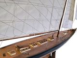 a wooden model of a sailboat with a white sail