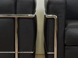 pair of black leather sofas with chrome legs in a living room
