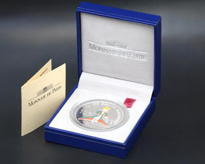 a close up of a silver coin in a blue box on a table
