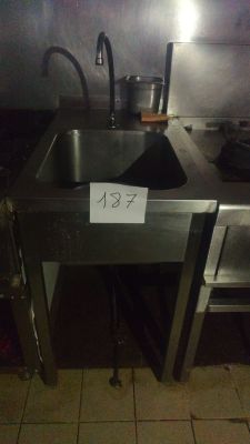 une cuisine équipée d'un évier et d'une cuisinière sur laquelle est accrochée une pancarte