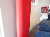 une grande lampe rouge qui se trouve à côté d'une chaise bleue