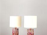 une paire de lampes en marbre posées sur une table, avec un abat-jour blanc
