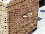 a wicker box sitting on a tiled floor
